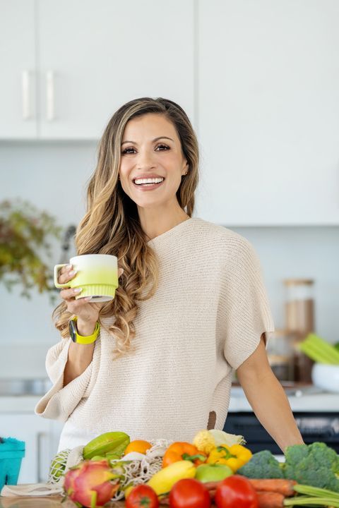 Cici holding a cup in the kitchen